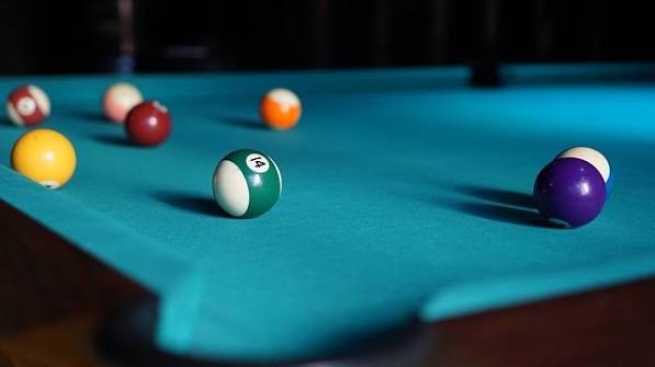 Colourful balls spread across a blue cloth pool table